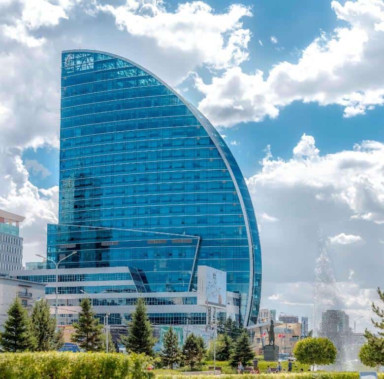 Photo de l'extérieur de l'hôtel Blue Sky à Oulan-Bator, avec un ciel chargé de nuages en arrière-plan.